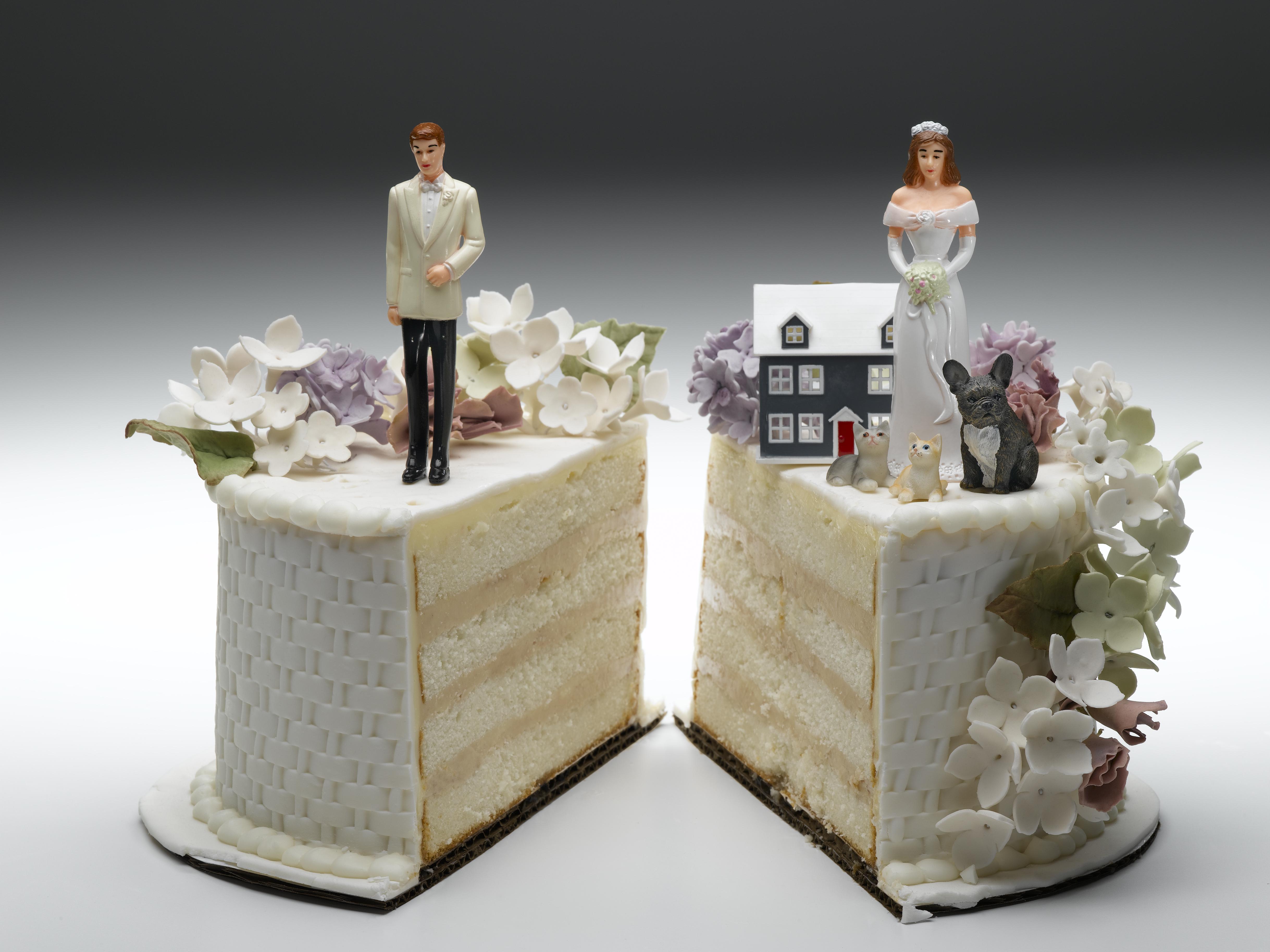 Bride and groom figurines standing on two separated slices of wedding cake