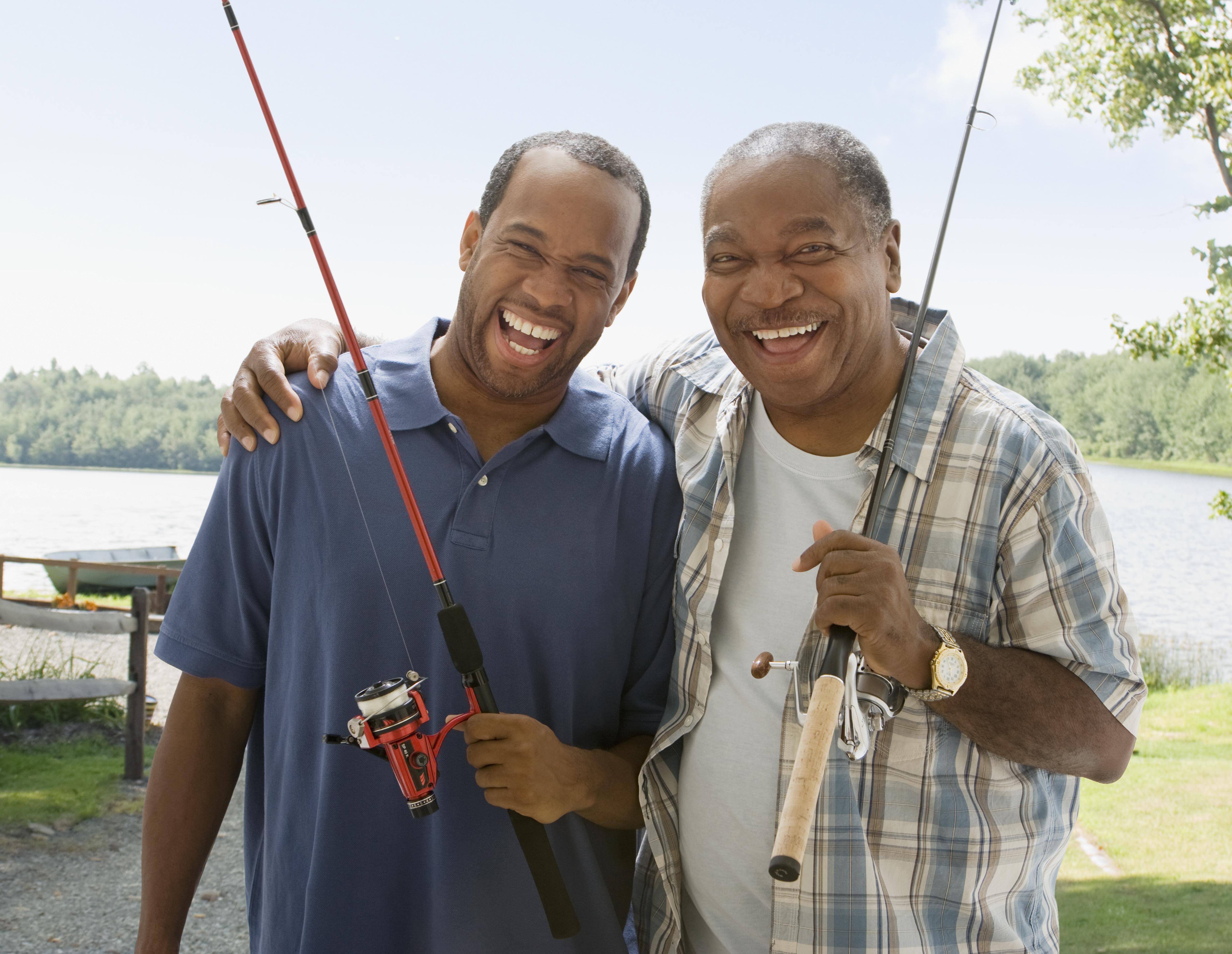 Portrait of father and son with fishing poles
