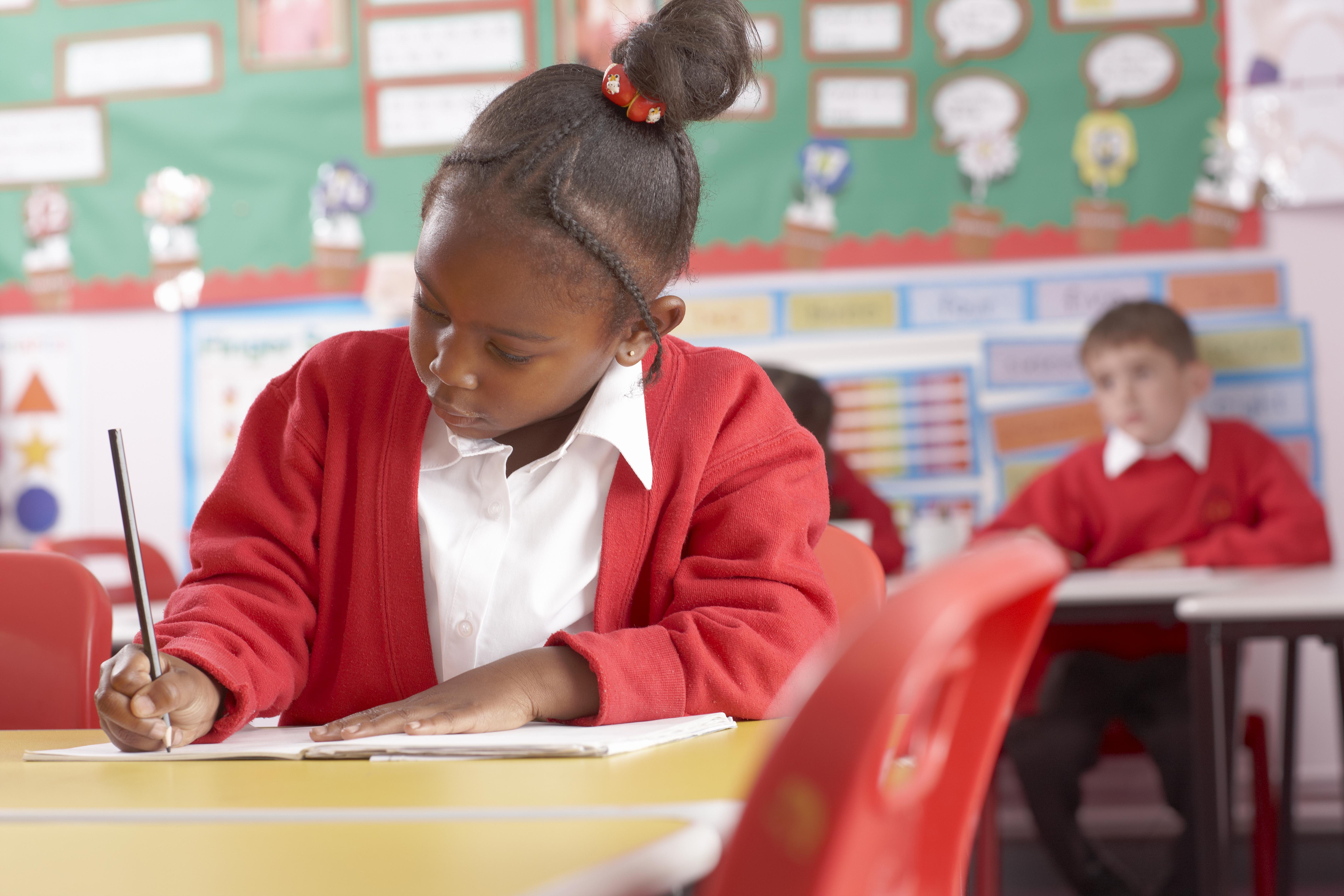 School child writing in book
