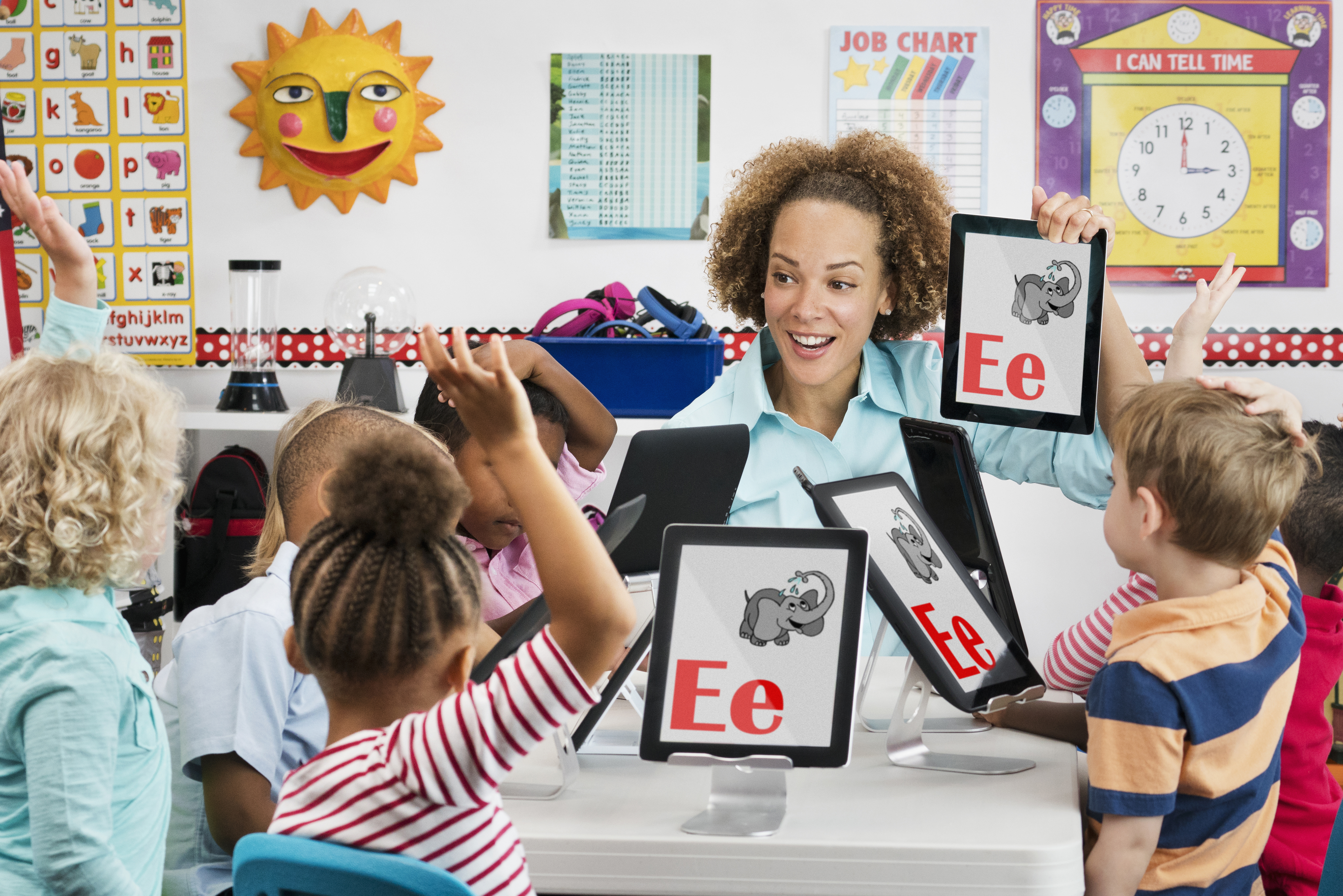 Teacher and students learning alphabet with digital tablets