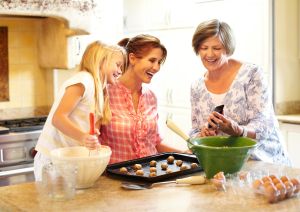 Grandmother showing smart phone to daughter and granddaughter