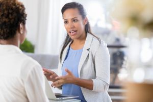 Businesswoman uses laptop while meeting with client