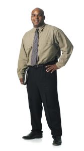 a young african american business man in a shirt and a tie smiles at the camera