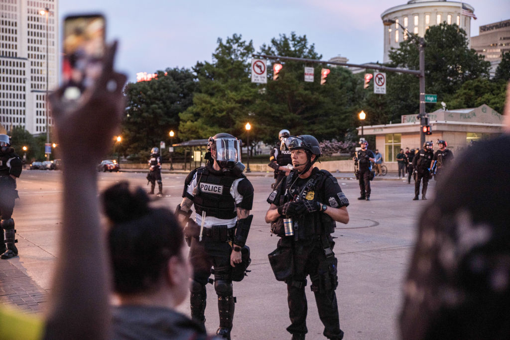 Riot police stand on guard outside the state house during...