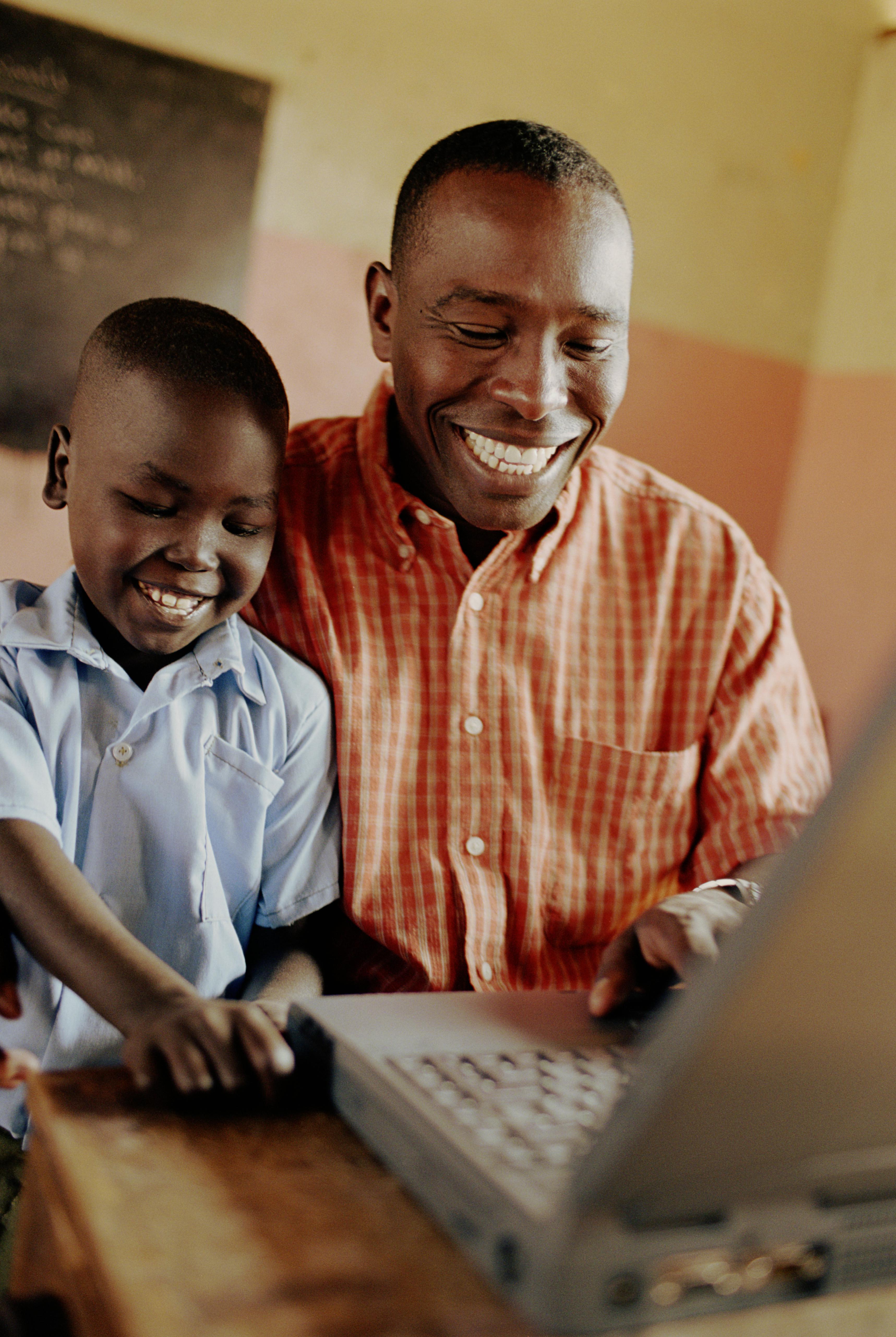 Teacher and student (6-8) working on laptop