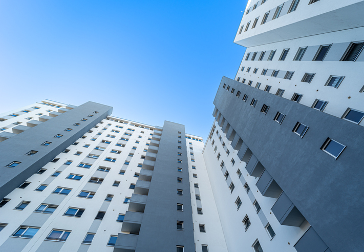 Low angle view of apartment building against clear blue sky